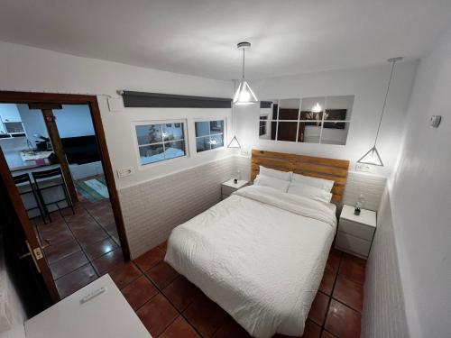 um quarto com uma cama branca e uma cozinha em Cozy Apartment In Rural Village em Barruelo de Santullán