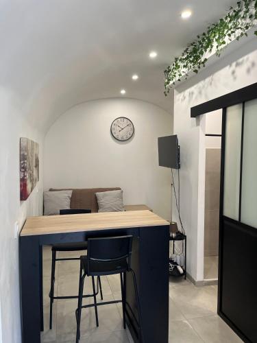 uma cozinha com um balcão e um relógio na parede em Agréable studio en plein coeur de ville em Saint-Jean-de-Védas