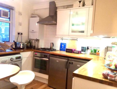 a kitchen with white cabinets and stainless steel appliances at Waterloo Central London in London