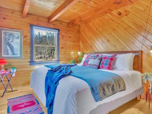 a bedroom with a bed in a log cabin at Skypine Lodge - Log Lodge Atop the World in Jim Thorpe