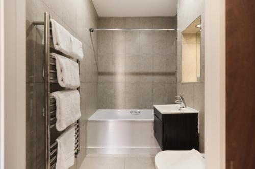 La salle de bains est pourvue d'une baignoire, de toilettes et d'un lavabo. dans l'établissement The Harlesden Hideout - Charming 2BDR Flat, à Londres