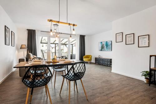 a dining room and living room with a table and chairs at I Zentral I Modern I Terrasse I in Rüsselsheim