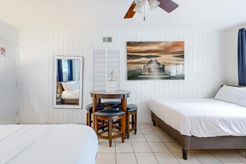 1 Schlafzimmer mit 2 Betten, einem Tisch und einem Stuhl in der Unterkunft Balboa Beauty III in Newport Beach