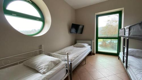 two beds in a room with a mirror and a window at Pokoje na Cyplu in Mrągowo
