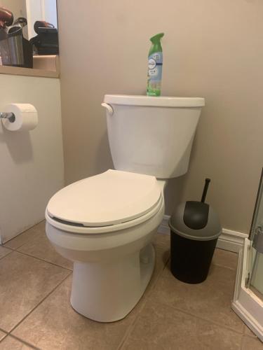 a bathroom with a toilet with a bottle on top of it at 2 bedroom basement with private side entrance in Guelph