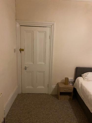 a bedroom with a door and a bed and a table at Palace in Crystal Palace