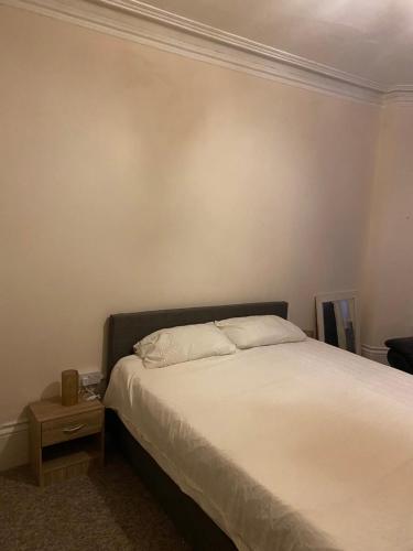 Schlafzimmer mit einem Bett und einem Beistelltisch in der Unterkunft Palace in Crystal Palace