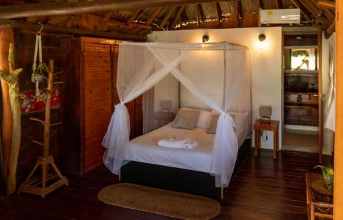a bedroom with a bed with a canopy at Kite Eco House in Salina de Rey