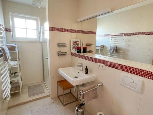 a white bathroom with a sink and a shower at GLÜCKSMOMENT - beeindruckende Ferienwohnung mit Pool in Seekirchen am Wallersee