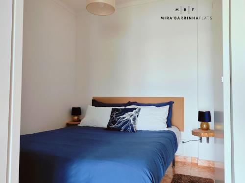 プライア・デ・ミラにあるMira'Barrinha Flatsのベッドルーム1室(青いシーツと枕のベッド1台付)