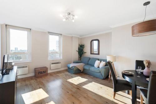 a living room with a blue couch and a table at New Luxury Close to Central London entire apartment flat Canary Wharf in London