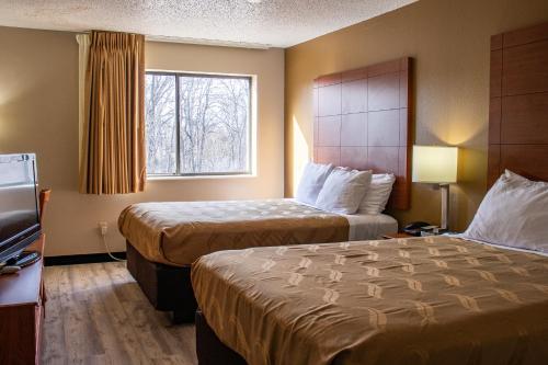 a hotel room with two beds and a window at Quality Inn Indianola in Indianola