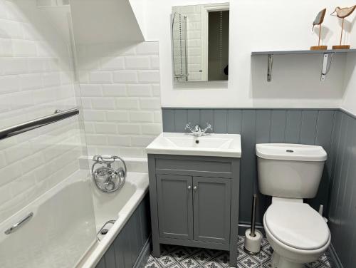 a bathroom with a toilet and a sink and a tub at Little Oaklands in Lostwithiel