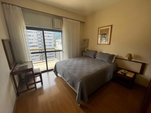 a bedroom with a bed and a large window at MC FLATS THE CLARIDGE in Rio de Janeiro