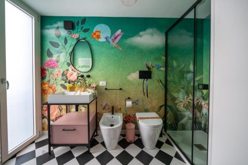 baño con aseo y un mural de flores en Casa Apuliae Bed & breakfast, en Bitonto