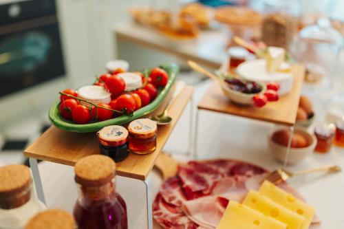 a buffet of food with tomatoes and cheese and jam at Casa Apuliae Bed & breakfast in Bitonto