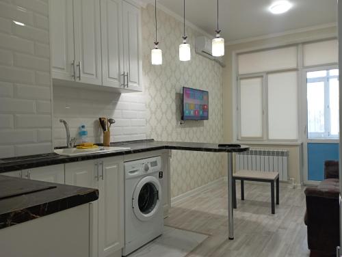 a kitchen with a washer and dryer in it at ЖК Арай in Aktobe