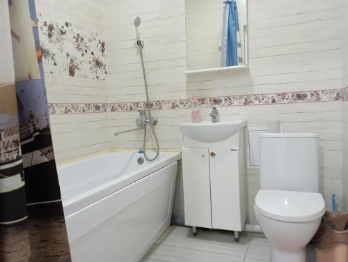 a bathroom with a toilet and a sink and a bath tub at ЖК Арай in Aktobe