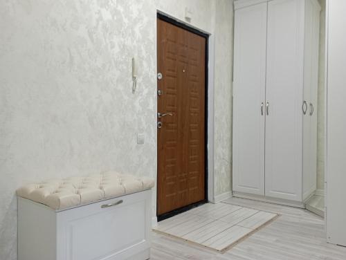 a room with a wooden door and a bench in front at ЖК Арай in Aktobe