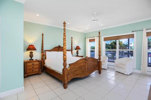 a bedroom with a bed and a chair and windows at Cape Palms in Cape San Blas