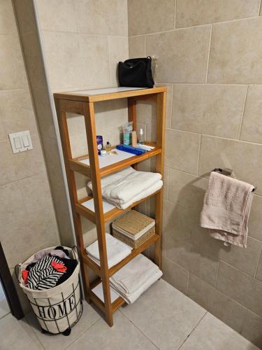 a bathroom with a wooden shelf with towels at Apartamento Bay View Panama cinta costera in Panama City