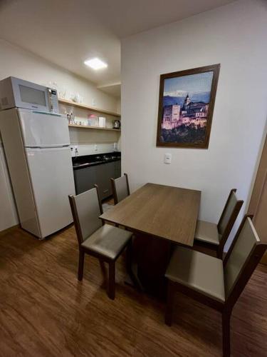 a kitchen with a table and chairs and a refrigerator at Studio no centro, novo com garagem in Santa Maria