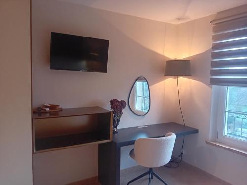 a room with a desk with a chair and a mirror at La porte rêvée... in Saint-Nicolas-de-la-Grave