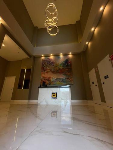 an empty room with a chandelier in a building at Apartamento 1 quarto, com garagem no centro próximo Hospital de Caridade in Santa Maria