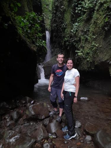 a man and a woman standing on rocks in a stream at Finca Del Cielo in El Castillo de la Fortuna