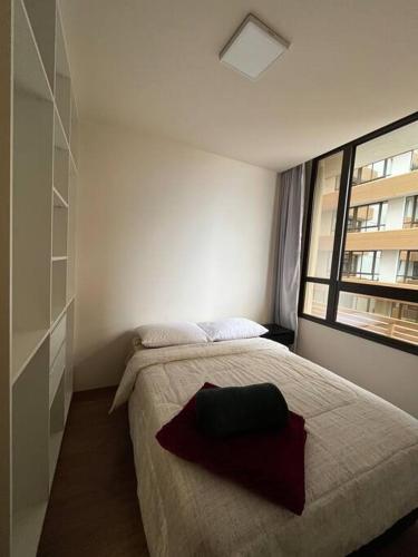 a bedroom with a large bed and a window at Studio no centro, novo com garagem in Santa Maria