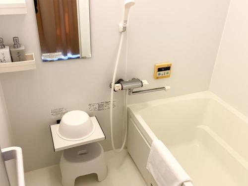 a white bathroom with a toilet and a bath tub at Nomura Building Parkside - Vacation STAY 34551v in Fuji