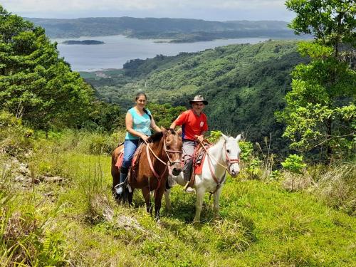 a man and a woman riding horses on a hill at Finca Del Cielo in El Castillo de la Fortuna