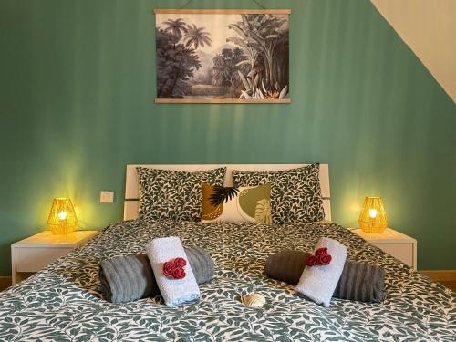 een slaapkamer met een bed met kussens erop bij Appart T4 spacieux & lumineux proche de la mer in Guidel