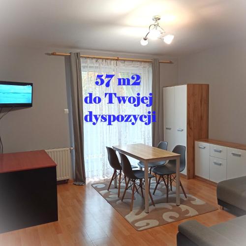 a kitchen and dining room with a table and chairs at Apartament Dunikowskiego 57m2 in Lublin