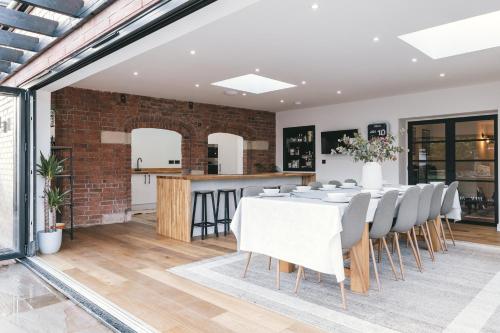 a dining room with a brick wall and a table and chairs at House with a cinema and games room, sleeps 17 in Shrewsbury