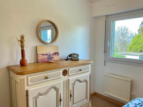 - une commode blanche dans une pièce avec un miroir dans l'établissement Appart T4 spacieux & lumineux proche de la mer, à Guidel