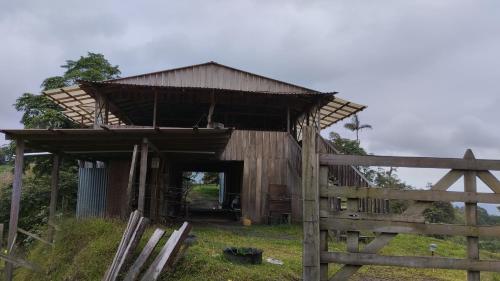 a wooden barn with a gate and a fence at Finca Del Cielo in El Castillo de la Fortuna