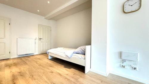 een slaapkamer met een bed en een klok aan de muur bij Studio Apartment - nahe Itzehoe in Itzehoe