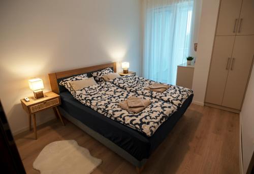 1 dormitorio con 1 cama con 2 lámparas en Mistral Residence 308, en Balatonföldvár