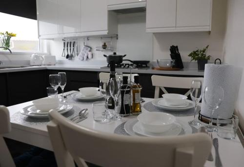 a table with plates and wine glasses on it at K&i Lakeside Retreat in Southport