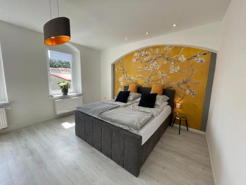 ein Schlafzimmer mit einem großen Bett mit gelber Wand in der Unterkunft Traumhaftes Meißen-Terrasse mit Burg-und Elbblick in Meißen