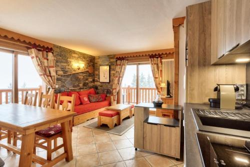 eine Küche und ein Wohnzimmer mit einem Sofa und einem Tisch in der Unterkunft Résidence Le Roselend - maeva Home - Appartement 3 Pièces 6 Personnes - Sé 82 in Bourg-Saint-Maurice