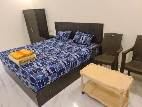 1 dormitorio con 1 cama y 2 sillas en Heaven Resorts, en Yercaud