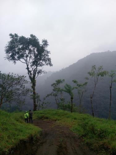 two people walking down a dirt road on a mountain at Finca Del Cielo in El Castillo de la Fortuna