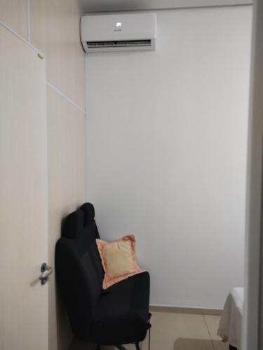 Genuino Sampaio的住宿－Quarto confortável em Est Velha，客房内的一张带枕头的黑椅子