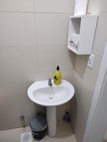 a white bathroom with a sink and a mirror at Quarto confortável em Est Velha in Genuino Sampaio