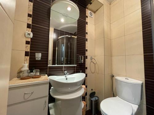 a bathroom with a toilet and a sink and a mirror at Charme apartman in Kruševac