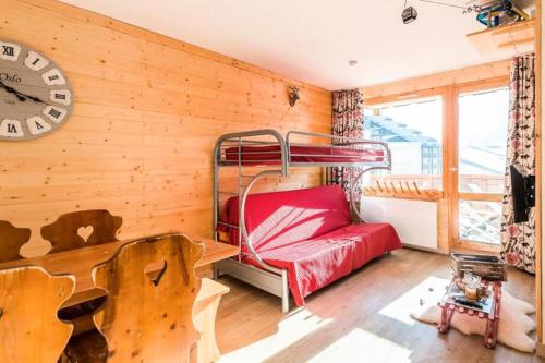- une chambre avec des lits superposés et une horloge murale dans l'établissement Résidence Les Temples du Soleil - maeva Home - 2 Pièces 5 Personnes Sélection MAE-1252, à Val Thorens
