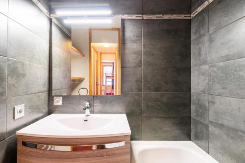 une salle de bain avec un lavabo, un miroir et une baignoire dans l'établissement Quartier La Forêt - maeva Home - 2 Pièces 5 Personnes Confort MAE-1276, à Valmorel