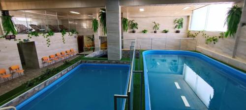 a large indoor pool with blue water in a building at HGA-Coral-Spa in La Paz